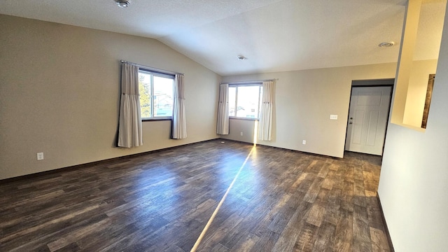 spare room with lofted ceiling and dark wood-style flooring