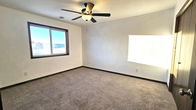 unfurnished bedroom featuring a textured ceiling, a closet, carpet flooring, and baseboards