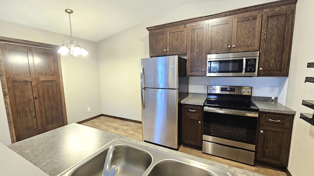 kitchen with vaulted ceiling, appliances with stainless steel finishes, pendant lighting, and dark brown cabinets