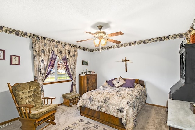 carpeted bedroom featuring ceiling fan and a textured ceiling