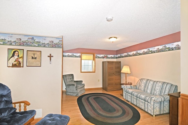 living room featuring light hardwood / wood-style floors and a textured ceiling