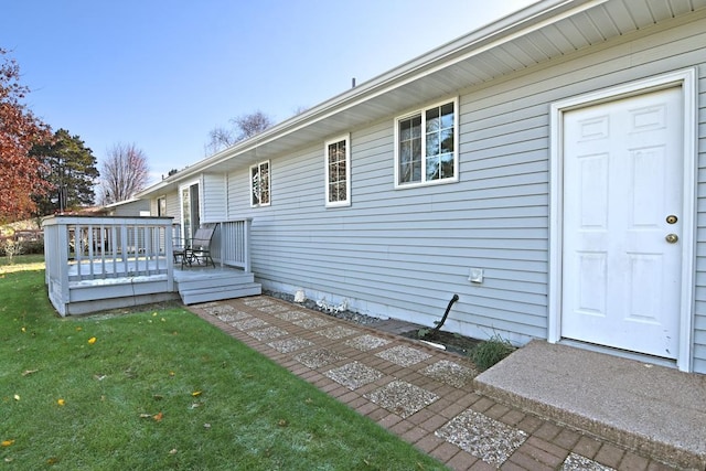 rear view of house with a wooden deck and a lawn