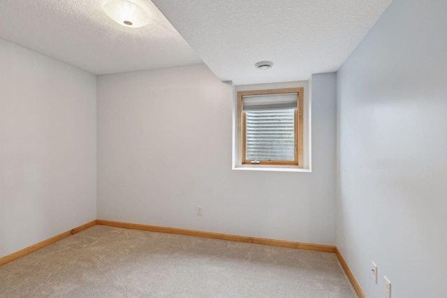 carpeted empty room with a textured ceiling