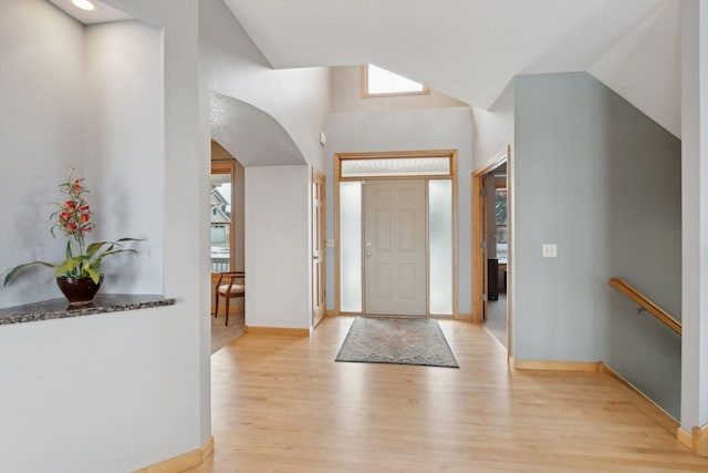 foyer entrance with vaulted ceiling and light hardwood / wood-style flooring