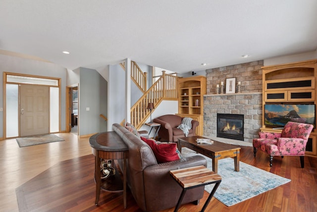 living room with hardwood / wood-style flooring and a brick fireplace