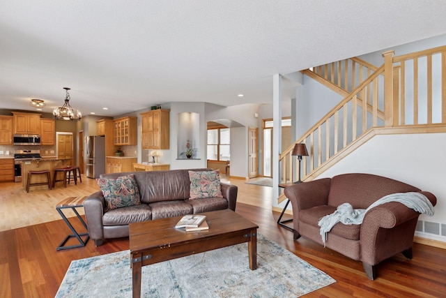 living room with light hardwood / wood-style floors and a chandelier