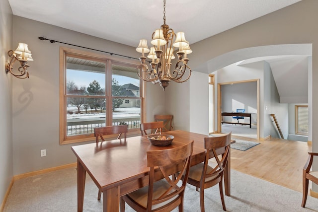 carpeted dining room with a chandelier