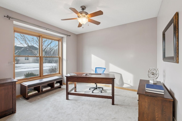 carpeted office space featuring ceiling fan