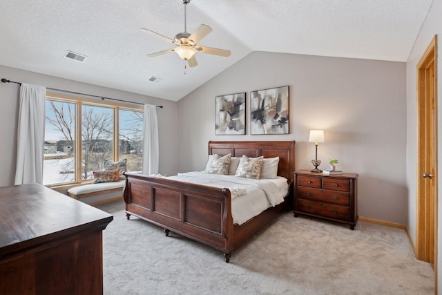 carpeted bedroom featuring ceiling fan, lofted ceiling, and a textured ceiling