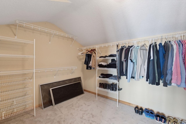 spacious closet featuring lofted ceiling and carpet floors