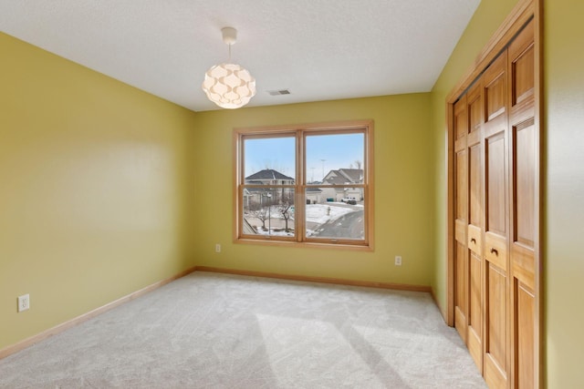 unfurnished bedroom featuring light colored carpet and a textured ceiling