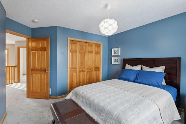 bedroom featuring light carpet, a closet, and a textured ceiling