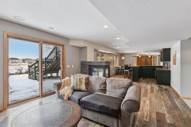 living room featuring sink, hardwood / wood-style floors, and a textured ceiling