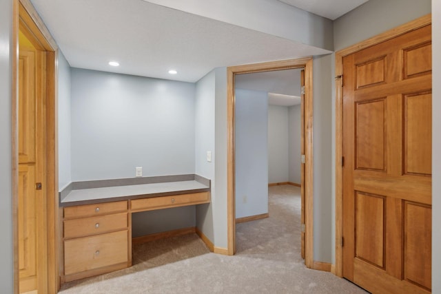 interior space with light carpet and built in desk