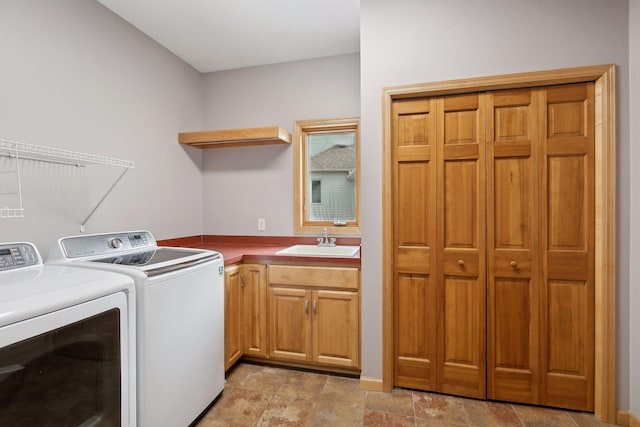 washroom featuring cabinets, washing machine and clothes dryer, and sink