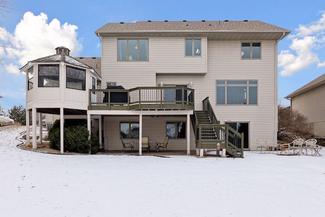 snow covered property with a wooden deck