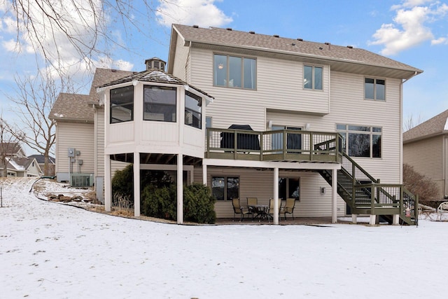 snow covered house featuring a deck