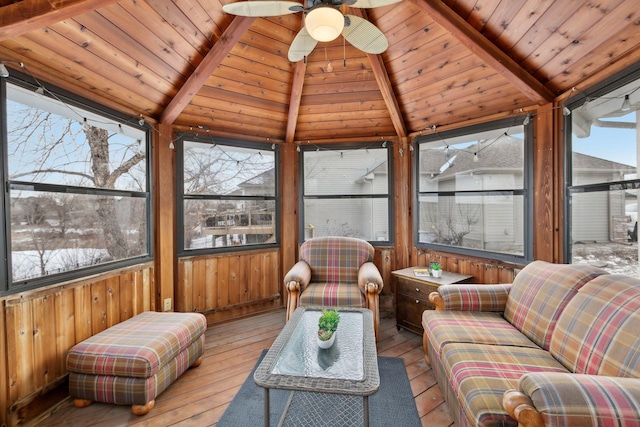 sunroom / solarium featuring ceiling fan, lofted ceiling with beams, and wooden ceiling