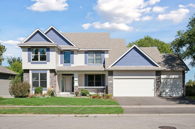 craftsman-style home with a porch, a garage, and a front yard