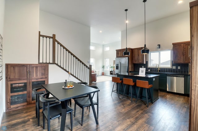 dining space featuring sink, dark hardwood / wood-style flooring, and a high ceiling