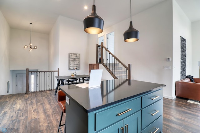 kitchen with blue cabinetry, an inviting chandelier, decorative light fixtures, and dark hardwood / wood-style floors