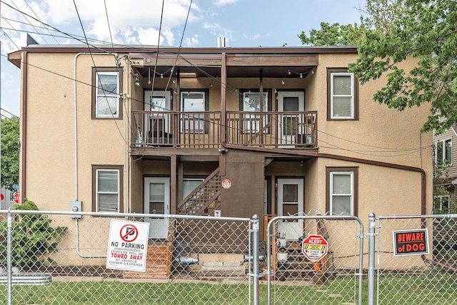 view of front of home with a balcony and a front lawn