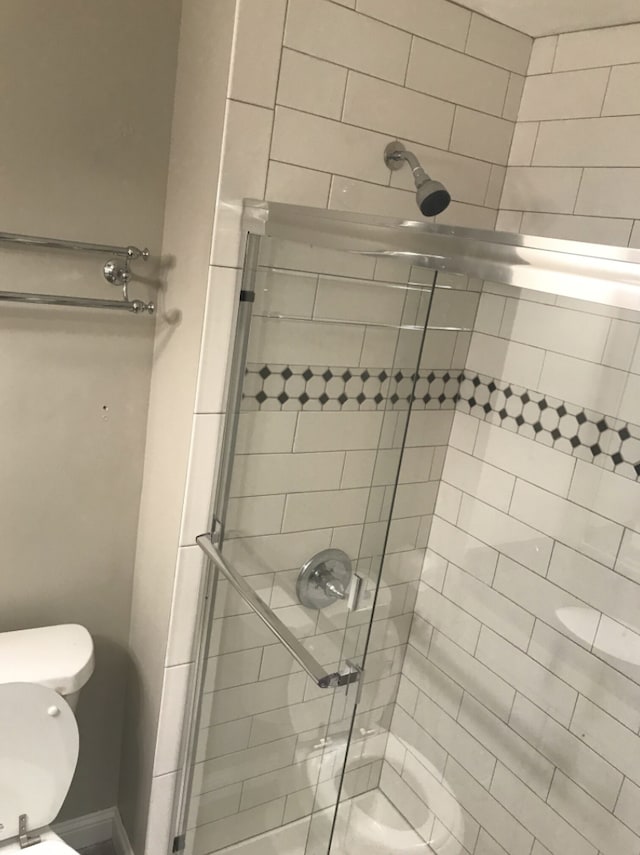 bathroom featuring toilet and walk in shower