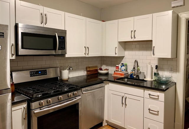 kitchen featuring white cabinets, tasteful backsplash, light wood-type flooring, sink, and stainless steel appliances