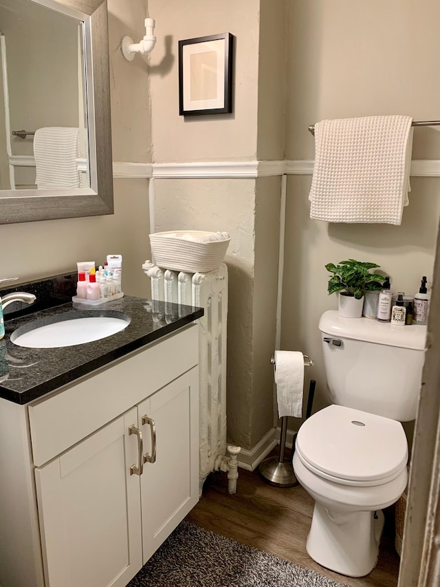 bathroom with vanity, radiator, toilet, and wood-type flooring