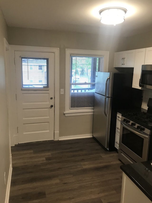 kitchen featuring appliances with stainless steel finishes, dark hardwood / wood-style floors, and white cabinets