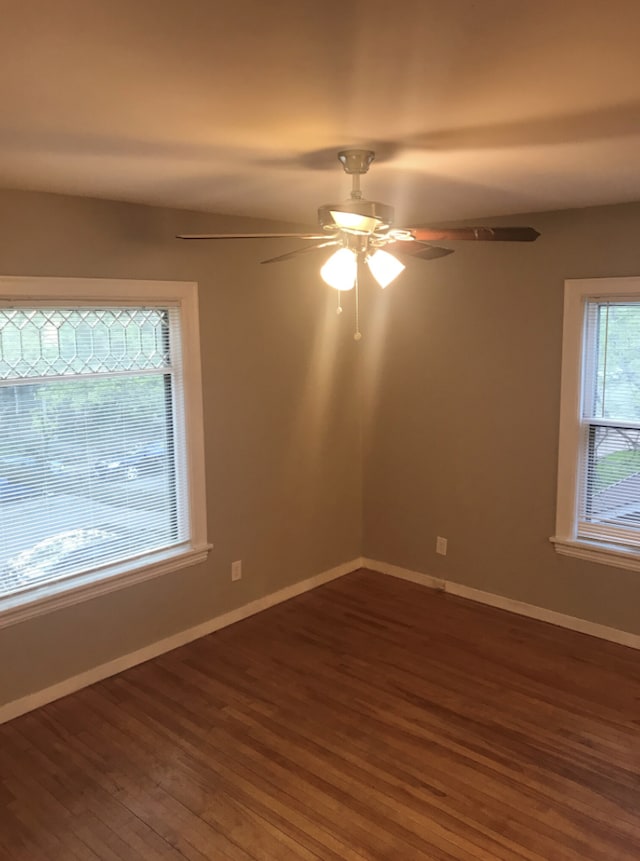 empty room with dark wood-type flooring and ceiling fan