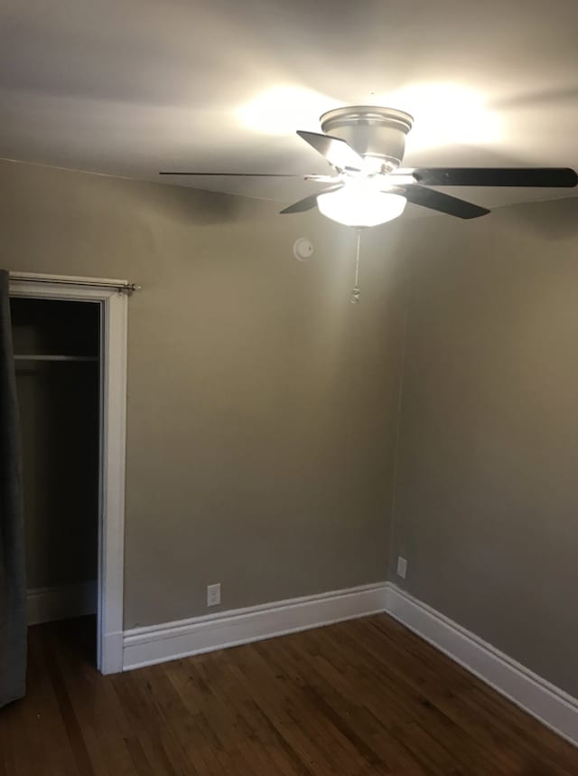 unfurnished room with dark hardwood / wood-style floors and ceiling fan