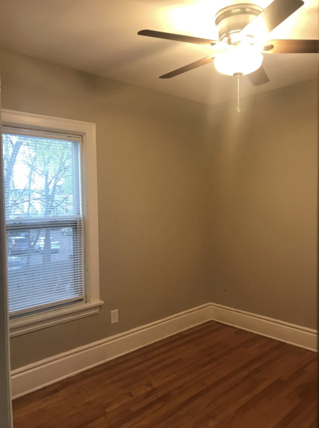 spare room featuring dark wood-type flooring and ceiling fan