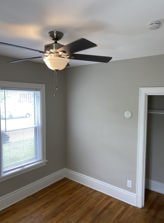 unfurnished room with dark hardwood / wood-style floors and ceiling fan