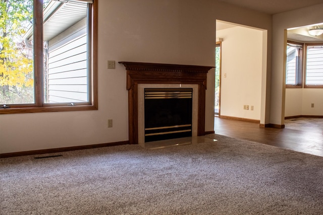 unfurnished living room with a wealth of natural light and dark hardwood / wood-style floors