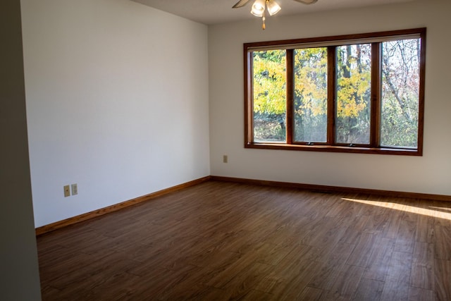 unfurnished room with ceiling fan and dark wood-type flooring