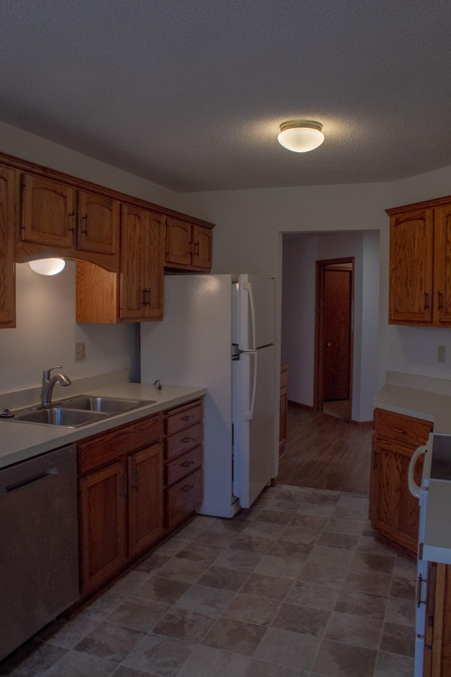 kitchen featuring stove, a textured ceiling, sink, light hardwood / wood-style flooring, and dishwasher