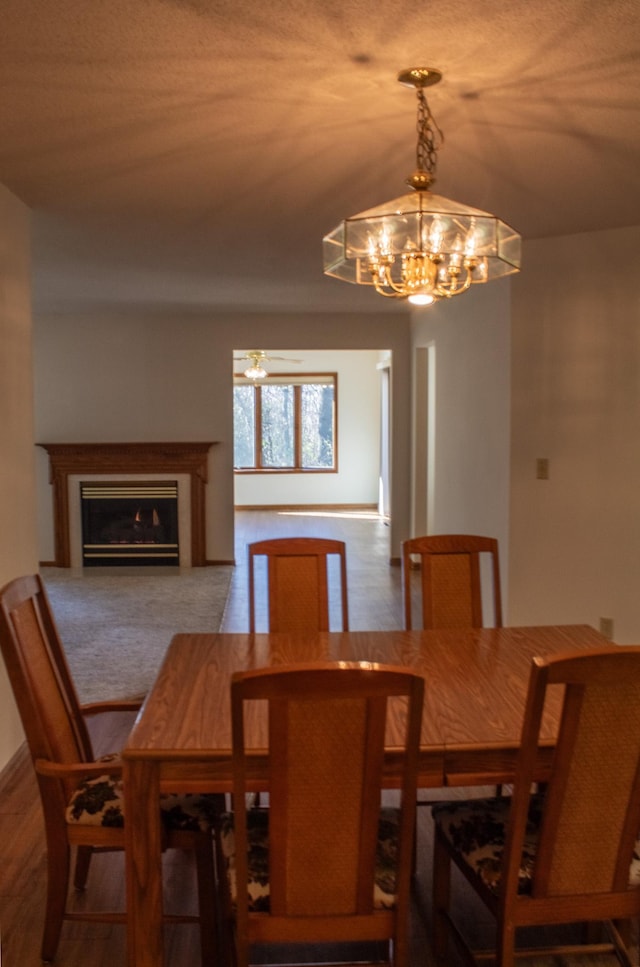 dining space featuring hardwood / wood-style flooring and ceiling fan with notable chandelier