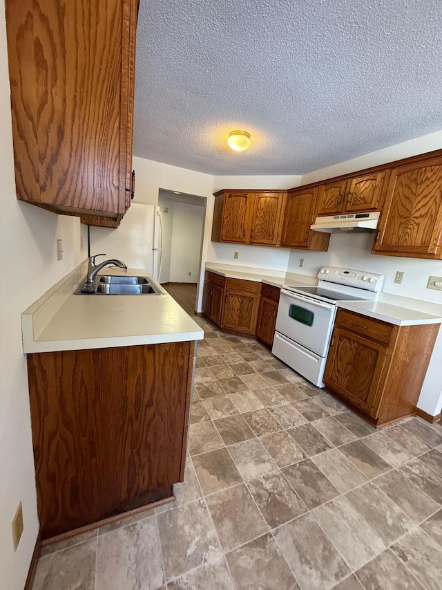 kitchen featuring white electric stove, brown cabinetry, light countertops, under cabinet range hood, and a sink