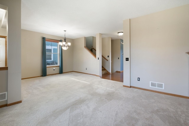 carpeted spare room with a chandelier