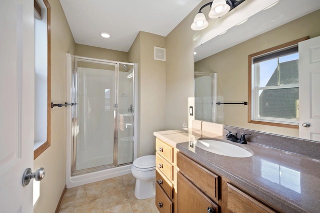 bathroom featuring tile patterned flooring, a shower with door, vanity, and toilet