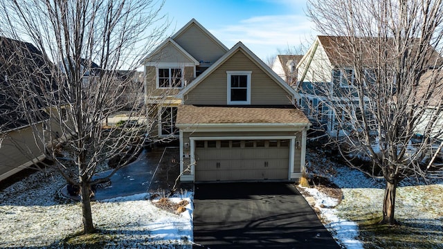 view of front of property featuring aphalt driveway, an attached garage, and a shingled roof