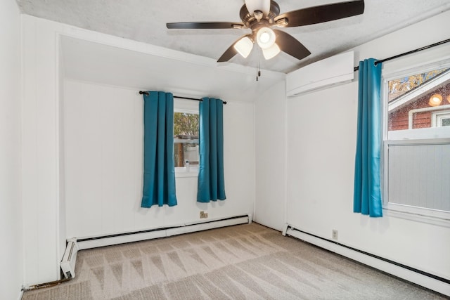 spare room featuring a baseboard radiator, light carpet, a healthy amount of sunlight, and ceiling fan