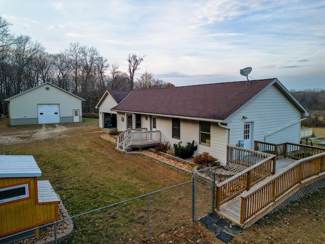 rear view of property with an outbuilding, a garage, a yard, and a deck