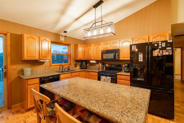 kitchen with black appliances, light parquet flooring, pendant lighting, sink, and a center island