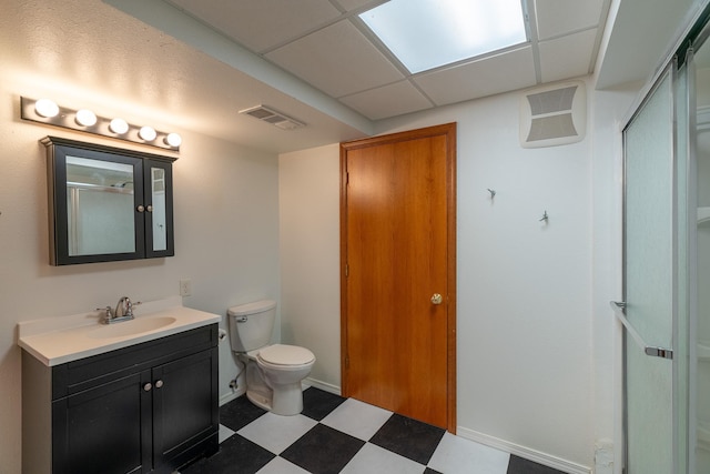 bathroom featuring toilet, an enclosed shower, vanity, and a paneled ceiling