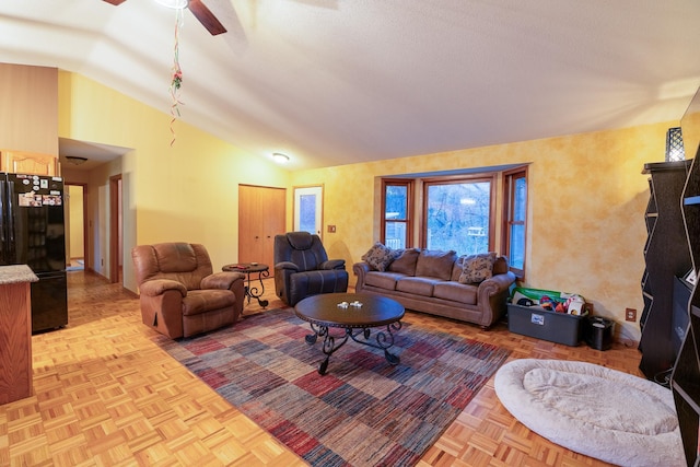 living room featuring ceiling fan, light parquet flooring, and vaulted ceiling