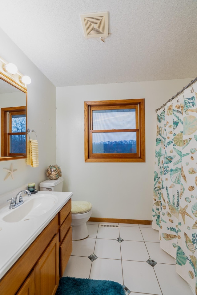 bathroom with vanity, a textured ceiling, a shower with shower curtain, tile patterned flooring, and toilet