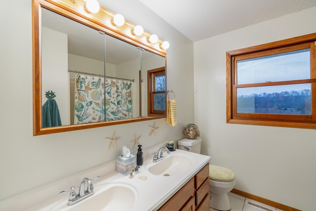 bathroom with a wealth of natural light, vanity, tile patterned floors, and toilet