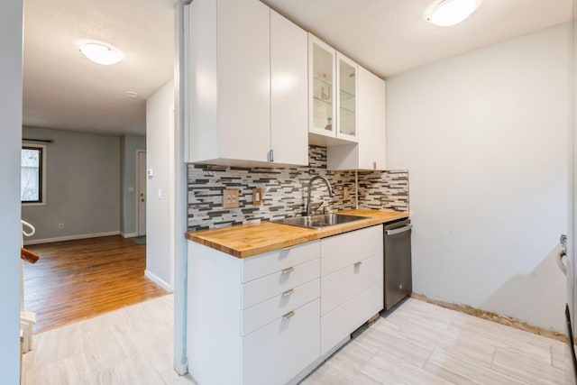 kitchen with white cabinets, sink, light hardwood / wood-style floors, and wood counters